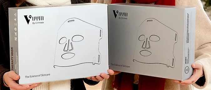 infrared mask Two skincare face mask boxes held by people.